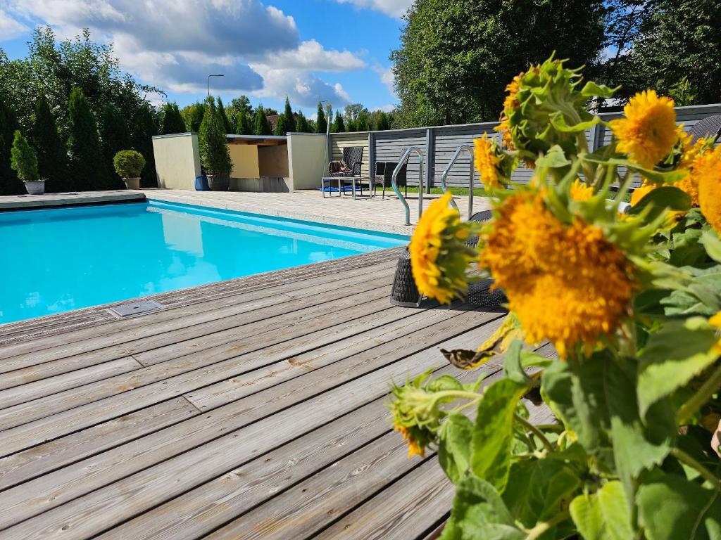 una terraza con girasoles junto a una piscina en "Summer" apartment, en Viljandi