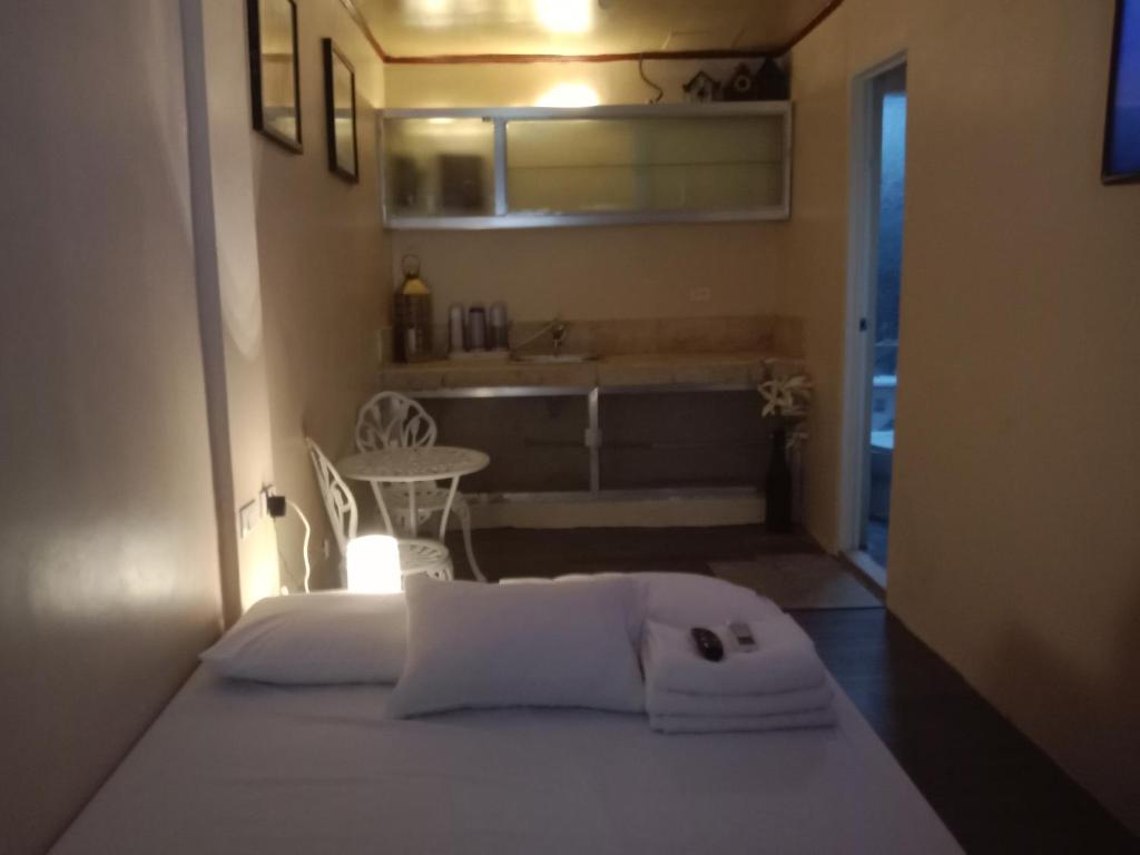 a white bed in a room with a bathroom at TerisitaPlace - LoveAtFirst in Taytay