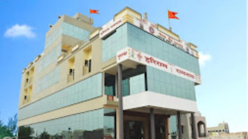 a building with red flags on top of it at Hotel Hariram Tower,Wardha in Wardha