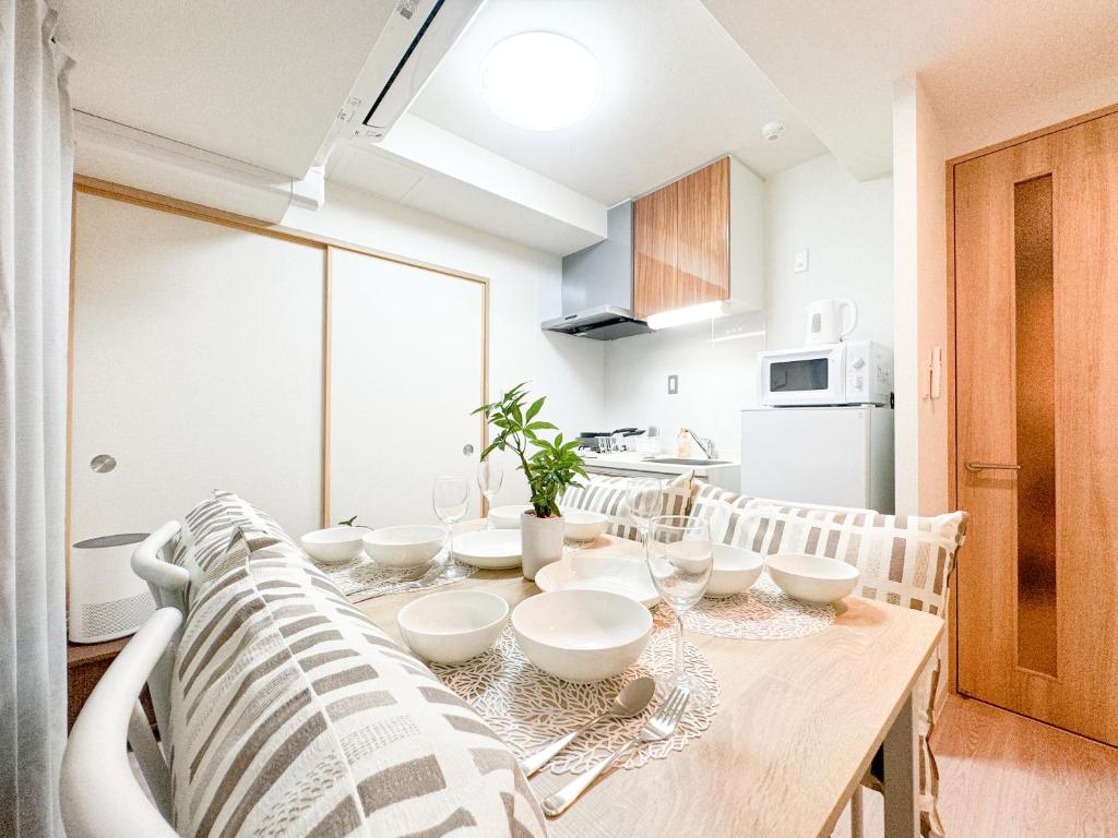a kitchen with a wooden table with white bowls on it at Apartment Hotel Side of Shinsaibashi Shopping street in Osaka