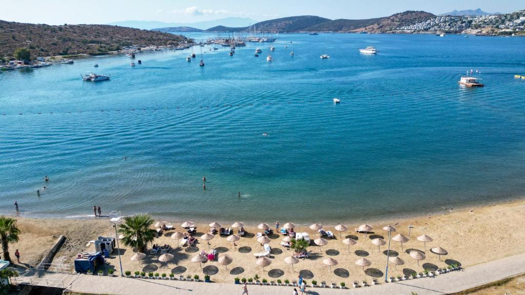 una playa con sombrillas y gente en el agua en Smart Stay Beach Bodrum -All Inclusive, en Gümbet