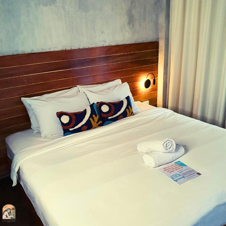 a white bed with pillows and towels on it at Luna Tres Homestay Siargao in General Luna