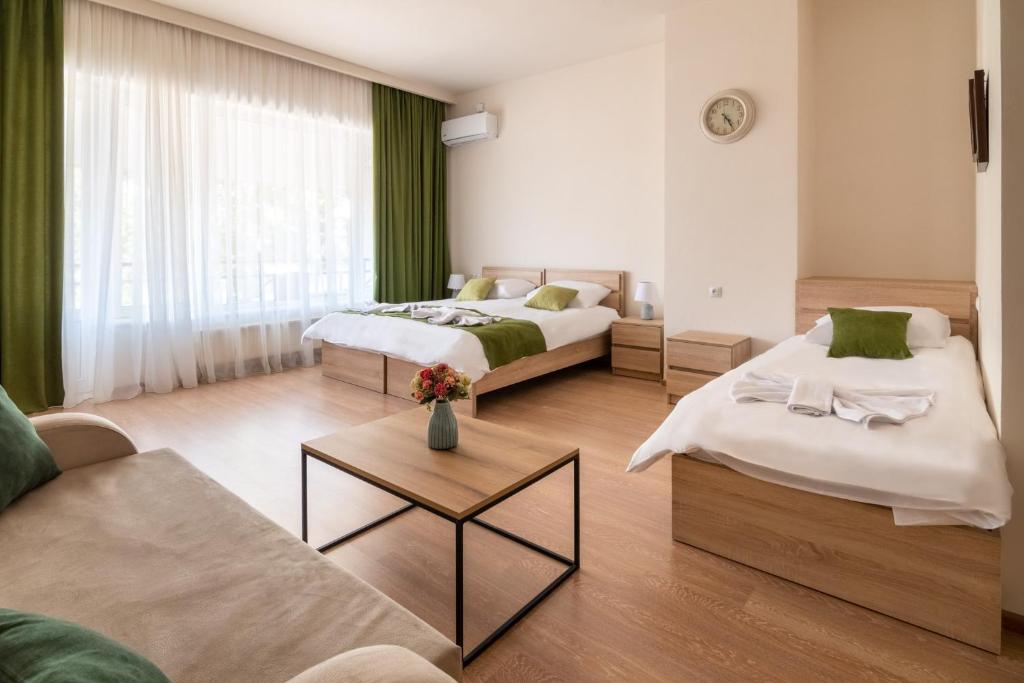 Habitación de hotel con 2 camas y sofá en New Tiflis Apartment Mziuri en Tiflis