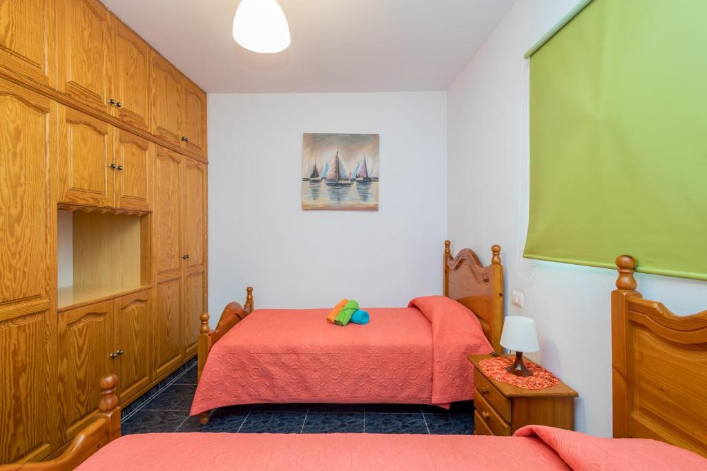A bed or beds in a room at Lightbooking Gadi House Tasarte terraza y barbacoa