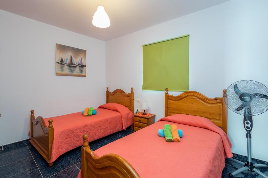 A bed or beds in a room at Lightbooking Gadi House Tasarte terraza y barbacoa