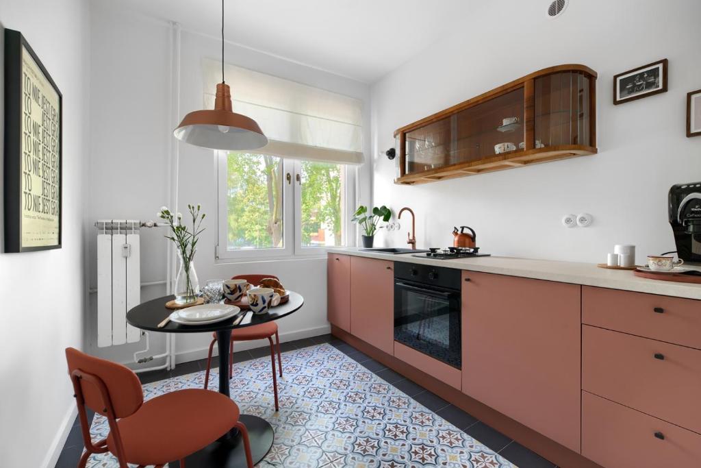 eine Küche mit einem Tisch, Stühlen und einem Waschbecken in der Unterkunft Apartament Szamotulska 59A in Posen