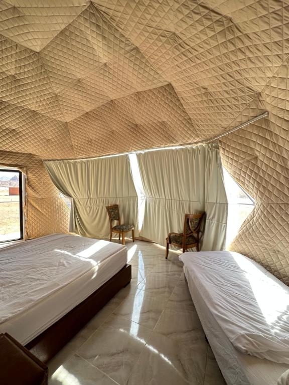 a bedroom with two beds in a tent at Wadi rum camp in Wadi Rum