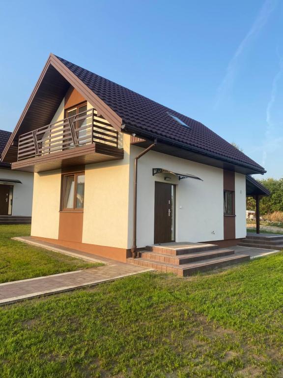 a house with a porch and a balcony at Biebrzańska Przystań in Goniadz