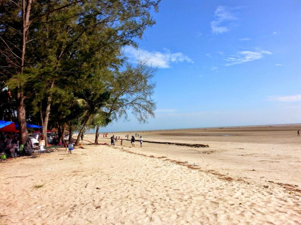 un groupe de personnes marchant sur une plage de sable dans l'établissement 3BR Retreat Homestay near to GoldCoast, Sepang by Verano, à Sungai Pelik