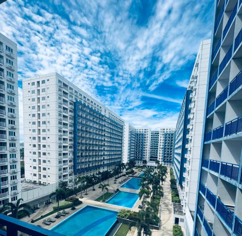 Sea Residences MOA-Eric Apartments في مانيلا: اطلالة على مدينة بها مسبح ومباني