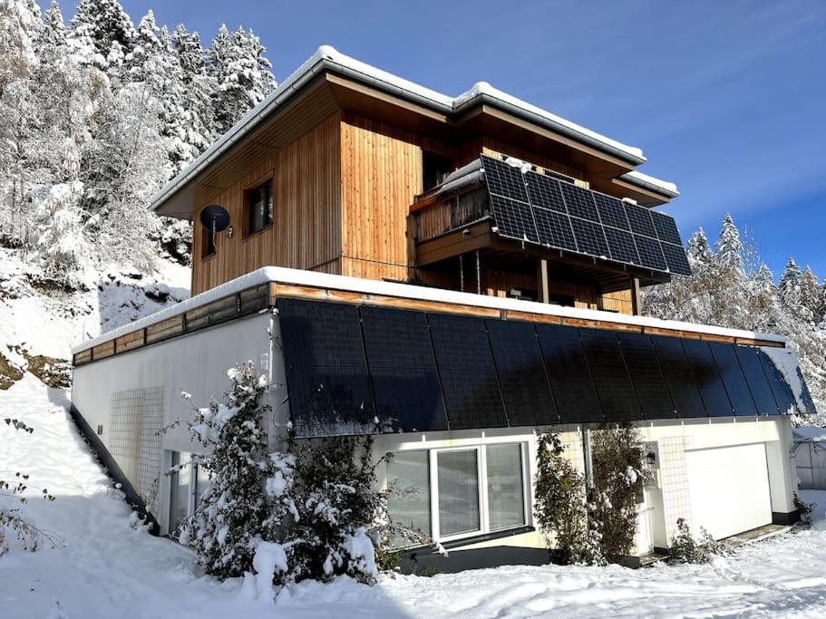 a house with solar panels on it in the snow at Green Mountain Retreat in Fliess