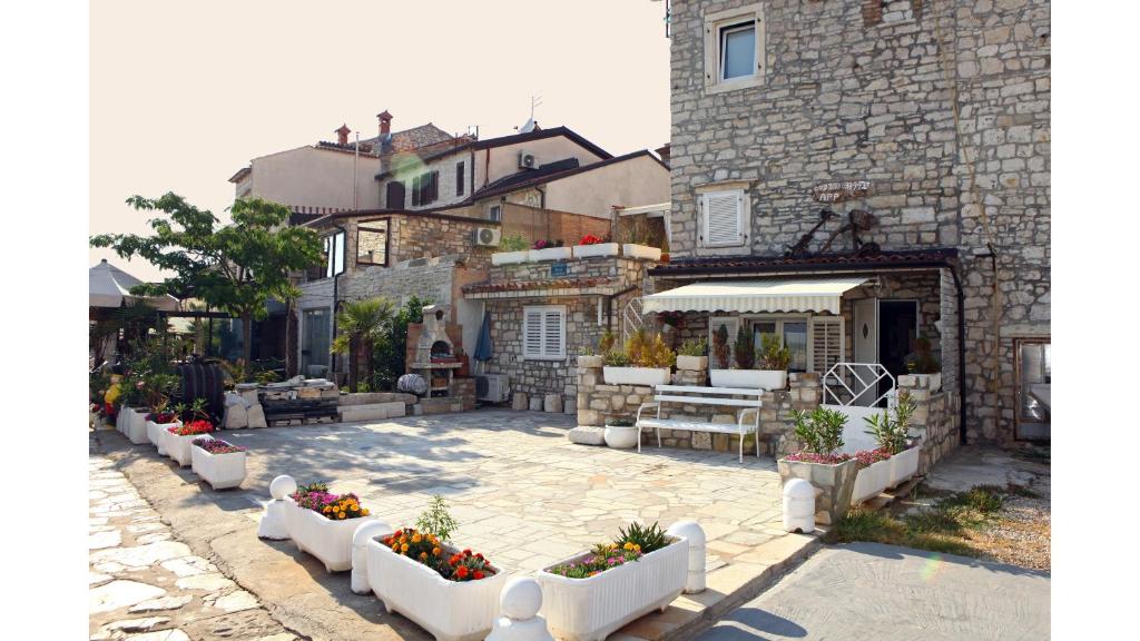 a patio with white furniture and flowers in front of a building at Lovely Apartment ES in Umag