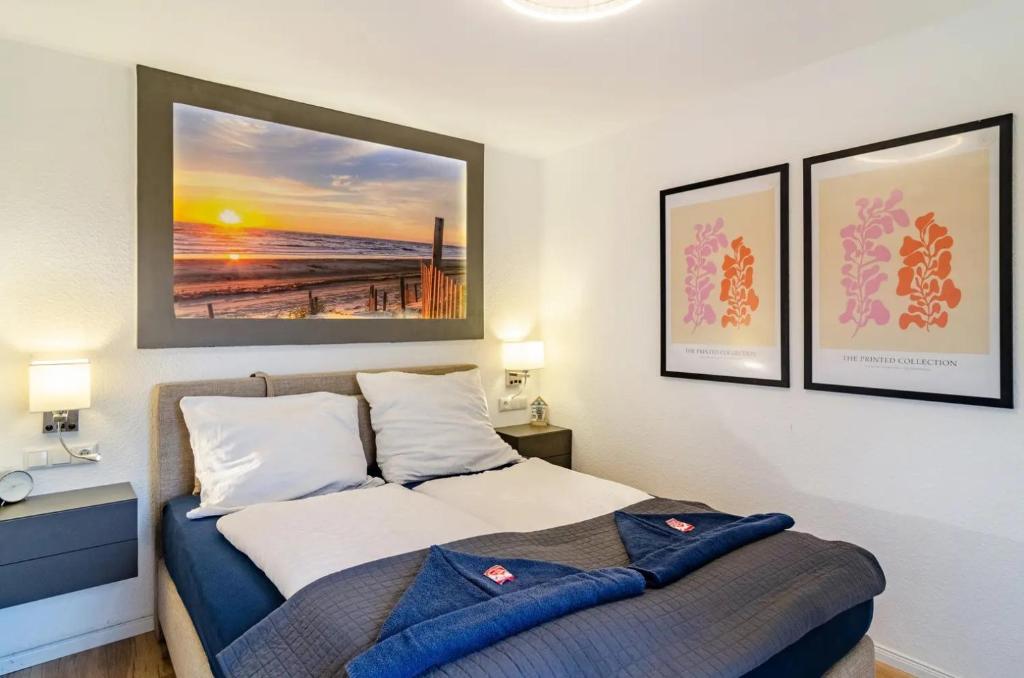 a bedroom with a bed and two pictures on the wall at Wellenrauschen - Whirlpool Badewanne - Terrasse - Ruhig gelegen in Wilhelmshaven