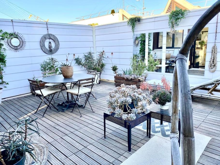 a patio with a table and chairs and potted plants at Duplex d'exception avec terrasse centre ville Montpellier in Montpellier