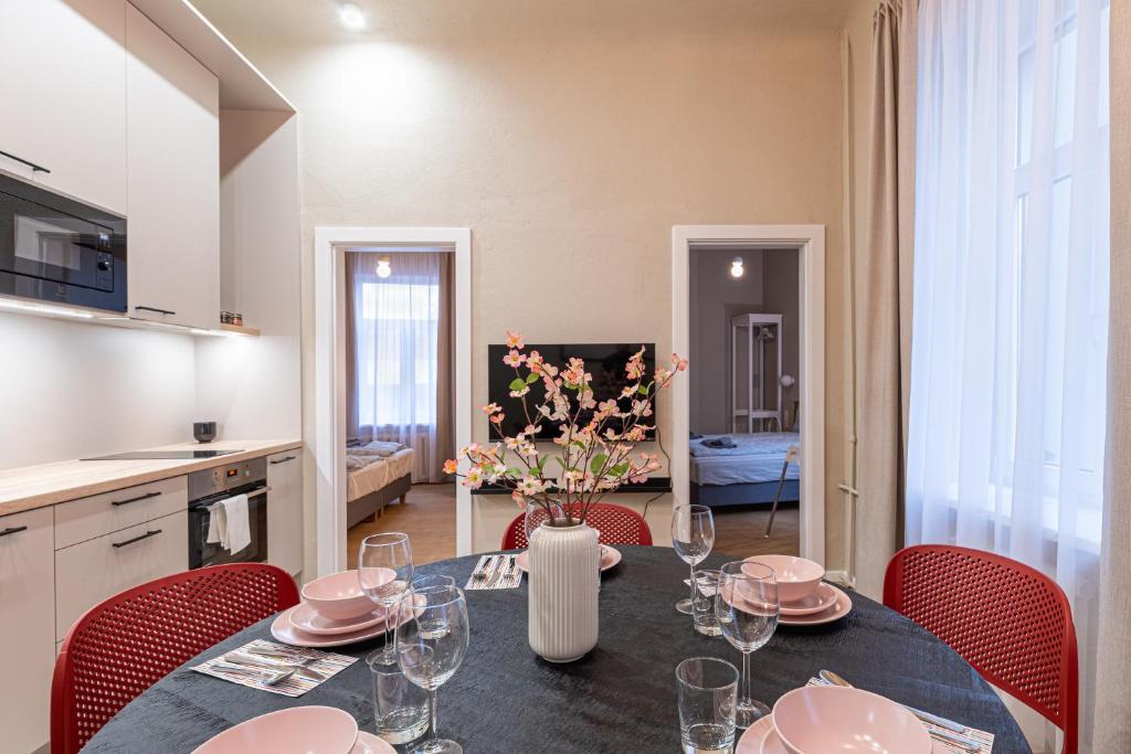 eine Küche und ein Esszimmer mit einem Tisch und Stühlen in der Unterkunft Dandelion Apartments Ģertrūdes in Riga