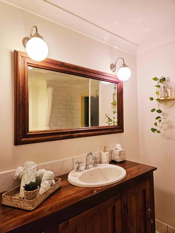 a bathroom with a sink and a mirror at The Gamekeepers Spa Cottage in Tamborine Mountain in Mount Tamborine