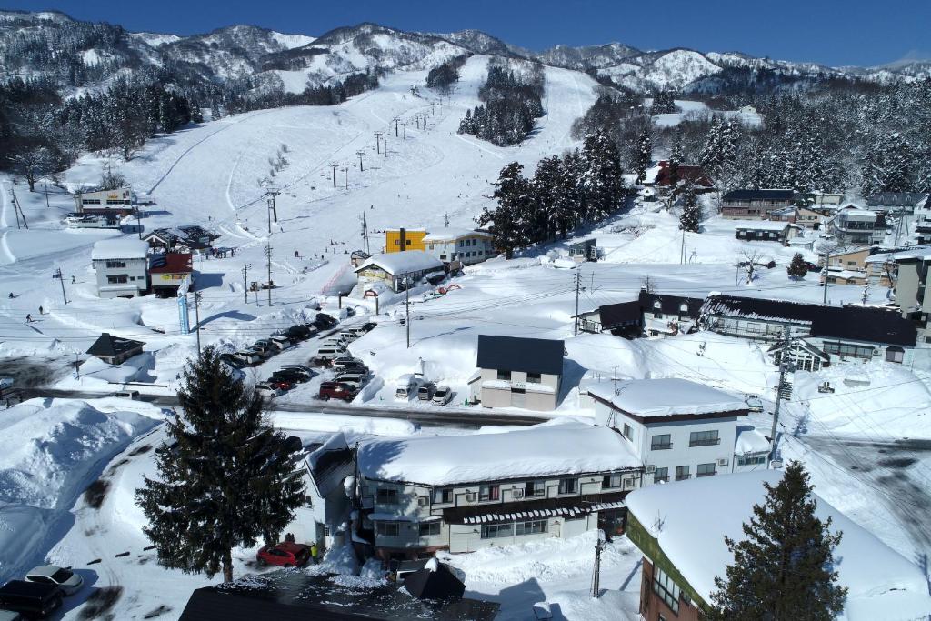 a town covered in snow with a ski slope at White Lodge Fukujuso in Iiyama