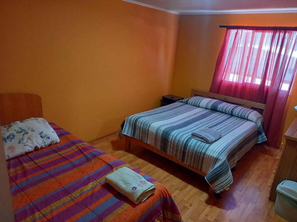 HOSTAL LA CASONA ALFREDO CAMPOS في اوفايي: غرفة نوم بسريرين ونافذة