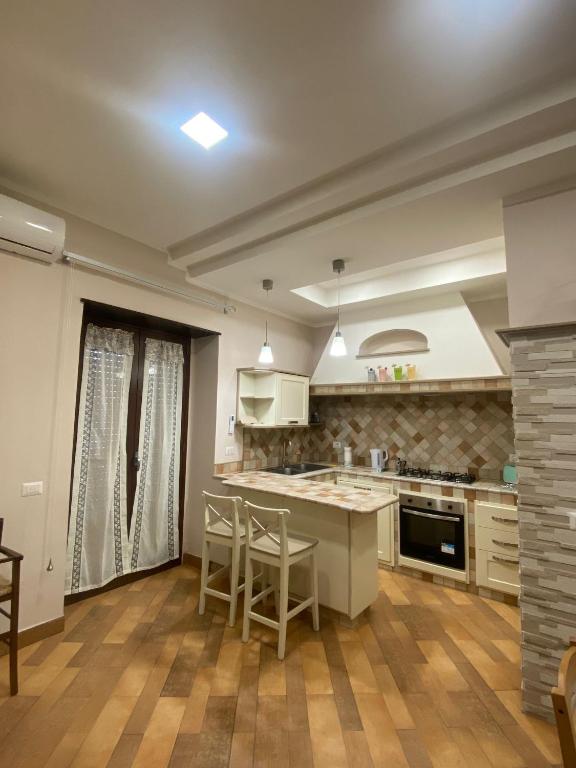 a kitchen with a counter and chairs in it at Domus Melius in Castellammare di Stabia