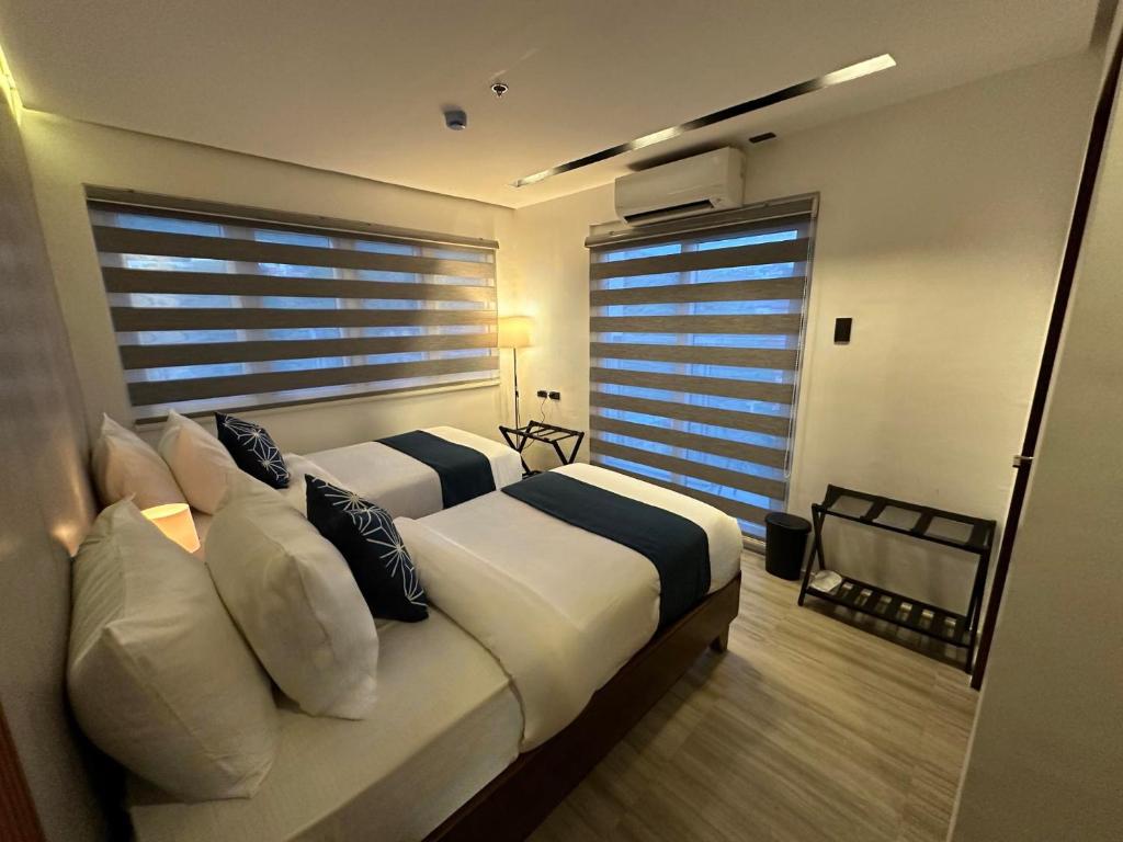 a bedroom with two beds and a large window at Coron 180 Hotel in Coron