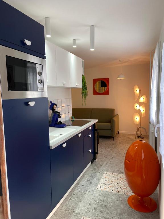 a kitchen with blue cabinets and an orange ball next to it at Orange & Art in Clermont-Ferrand