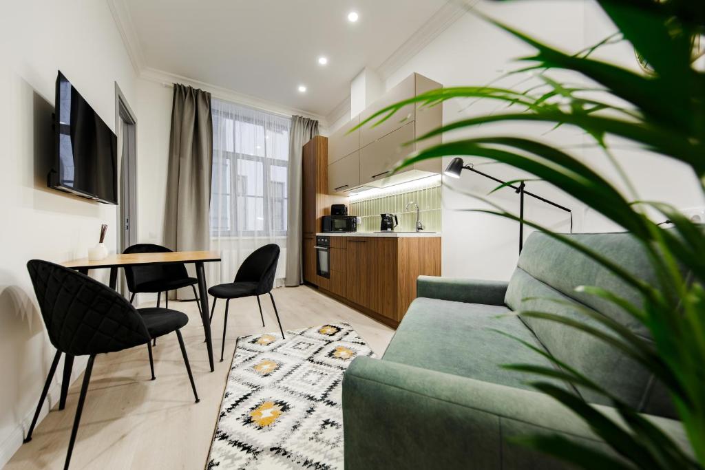 uma sala de estar com um sofá, uma mesa e cadeiras em RIGAAPARTMENT ELIZABETES 22 Self-Service Aparthotel em Riga