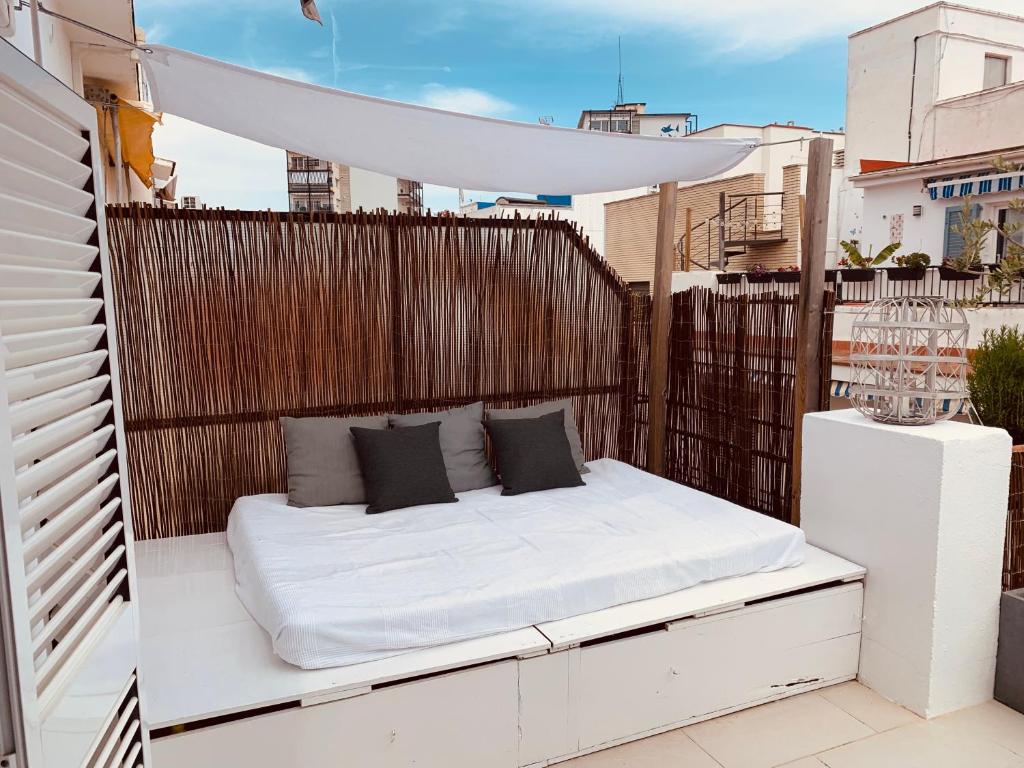 - un lit blanc sur un balcon à baldaquin dans l'établissement Penthouse Sitges, à Sitges