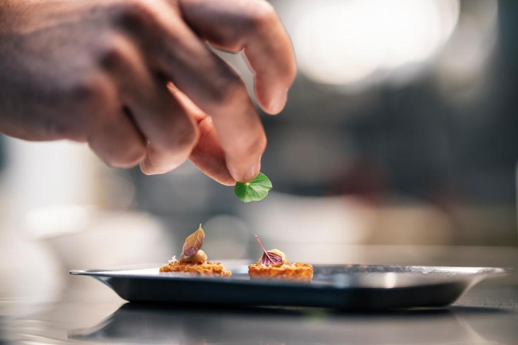 a person holding a leaf above a plate of food at Arribas Sintra Hotel in Sintra
