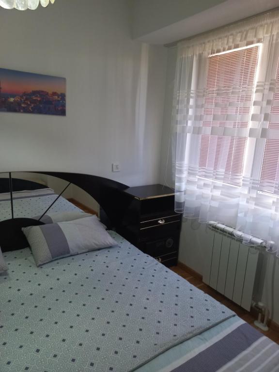 ein Schlafzimmer mit einem Bett, einer Kommode und einem Fenster in der Unterkunft Cozy Skopje Retreat in Skopje