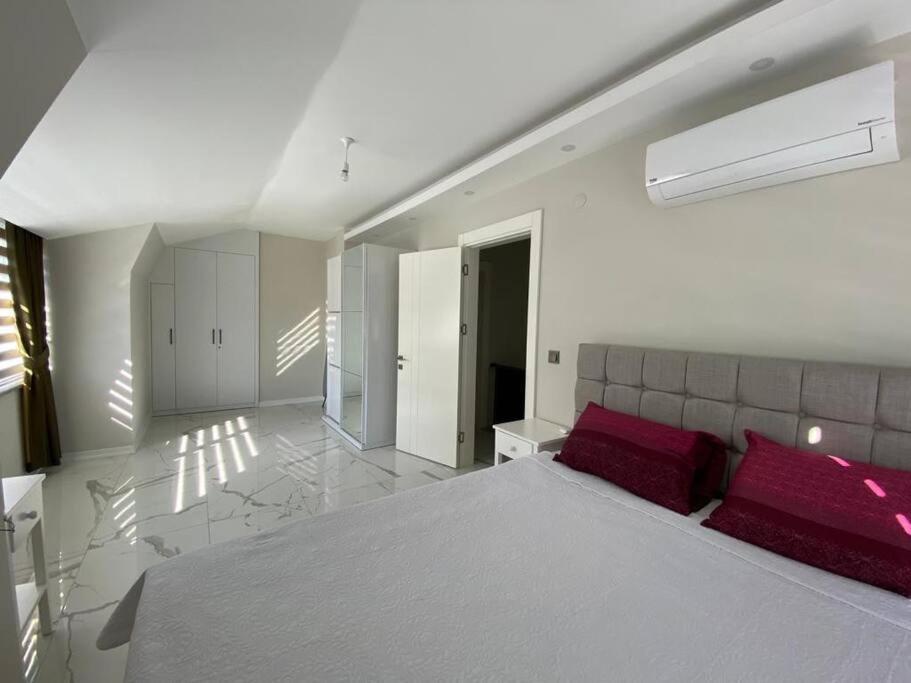 Retro 15 3+1 في ألانيا: غرفة نوم بيضاء مع سرير كبير مع وسائد حمراء