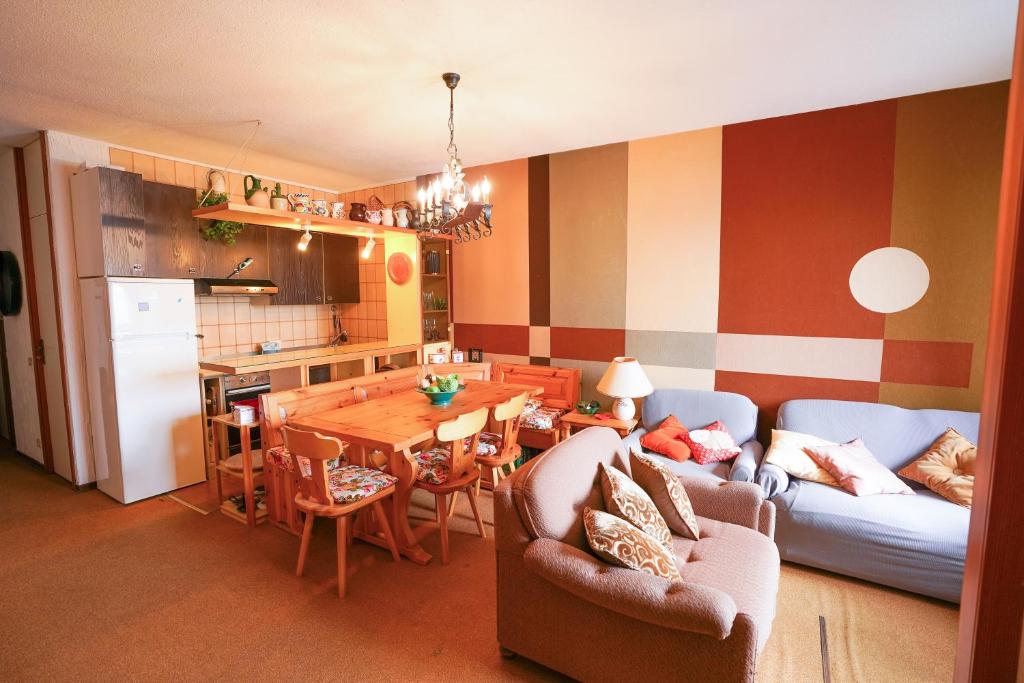 uma cozinha e sala de estar com uma mesa e um sofá em TRILOCALE sulle PISTE DA SCI em Case Arfel