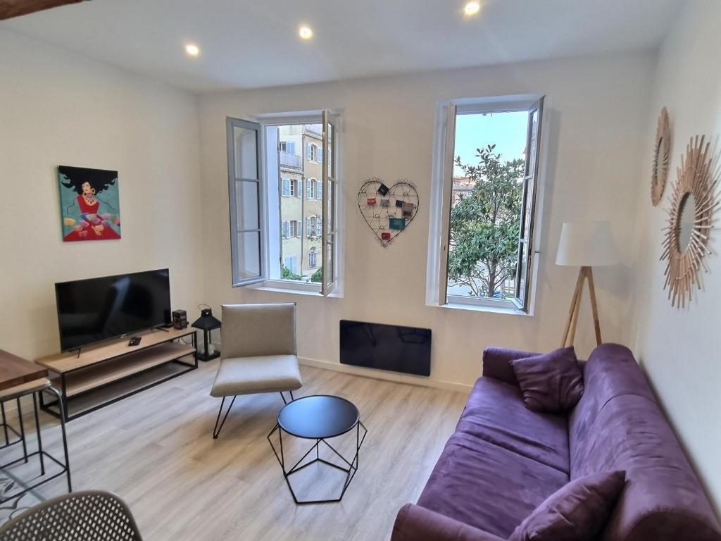 a living room with a purple couch and a tv at Appartement T2 40m2 Rénové Au Coeur du Panier Vieux Port in Marseille