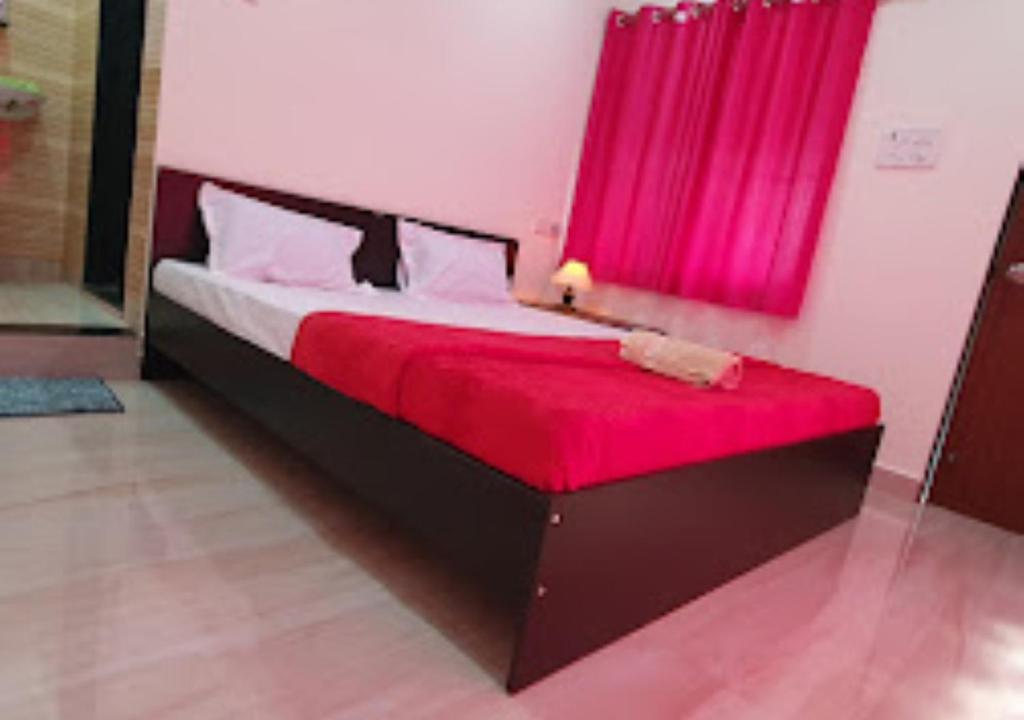 ein Schlafzimmer mit einem großen Bett mit einer roten Decke in der Unterkunft Serina House Malvan in Malvan