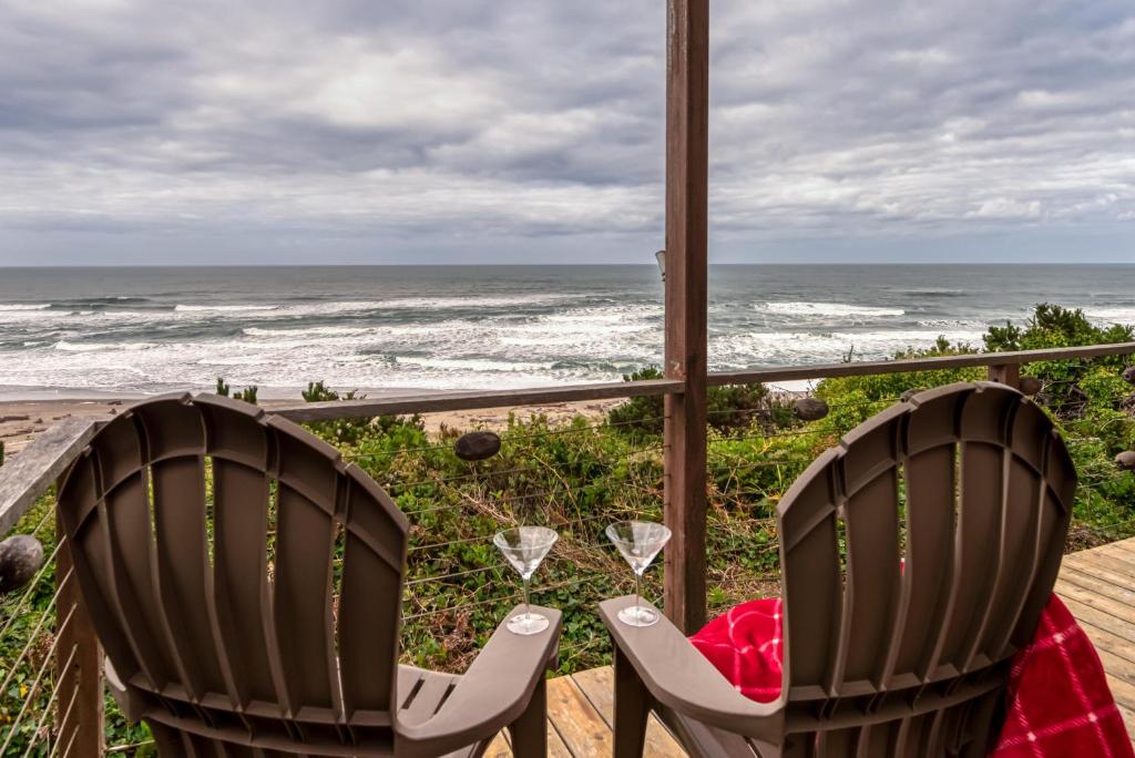 dwa krzesła na ganku z widokiem na ocean w obiekcie RidgeTop w mieście Lincoln City