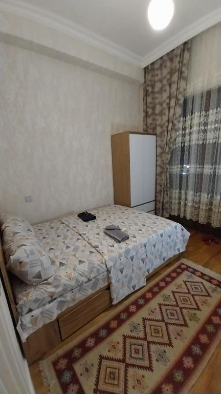 1 dormitorio con 1 cama en una habitación con alfombra en Banu House, en Sumqayit