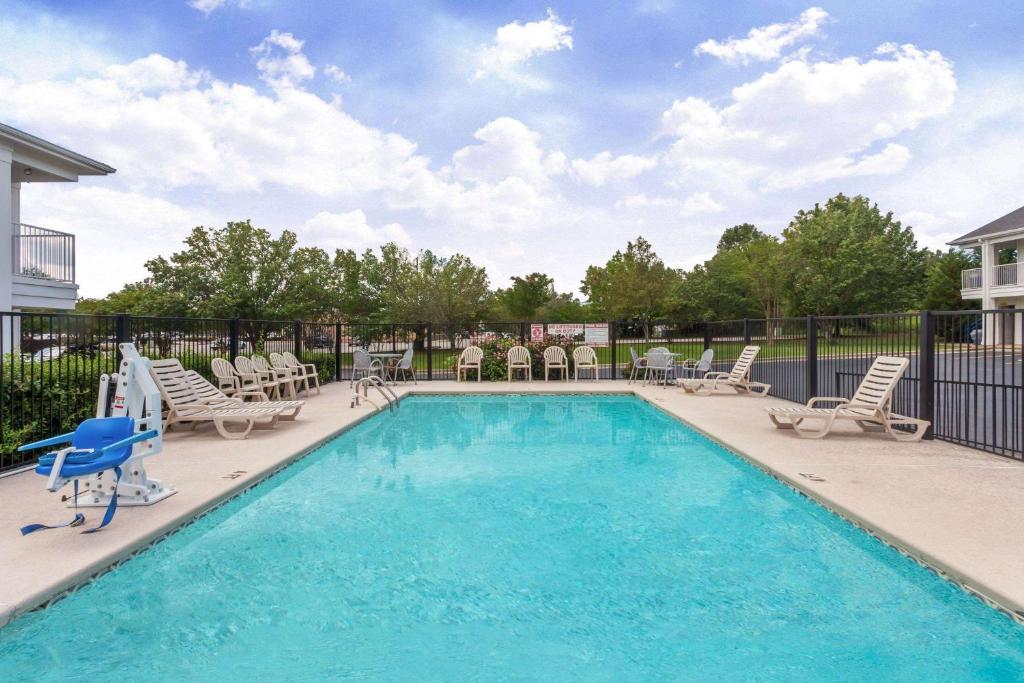 a swimming pool with chaise lounge chairs and a pool at Baymont by Wyndham Florence/Muscle Shoals in Florence