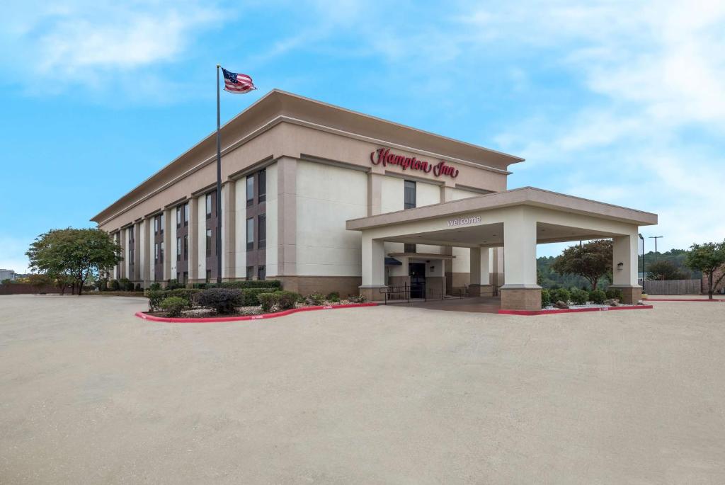 un edificio con una bandera americana delante de él en Hampton Inn Marshall, en Marshall