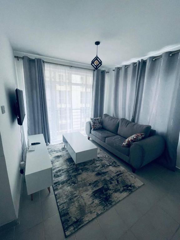 a living room with a couch and a table at One Bedrooms & Studios at Ngong Rd in Nairobi