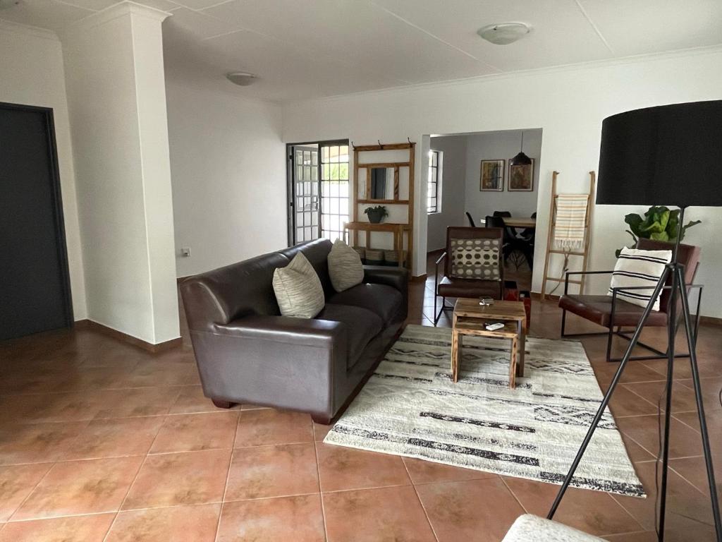 a living room with a leather couch and a table at City comfort self catering Windhoek in Windhoek