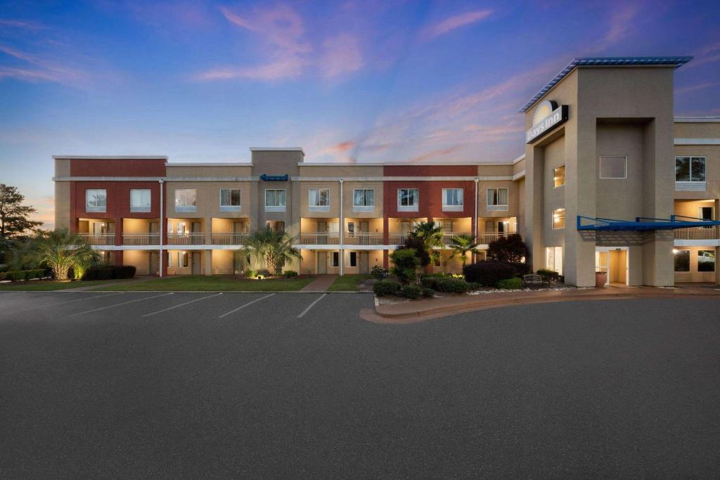 a large building with a parking lot in front of it at Days Inn by Wyndham Florence Near Civic Center in Florence