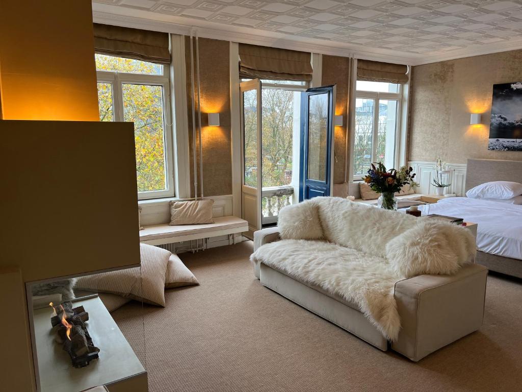 a living room with a couch and a bed at Park Mansion Hotel in Amsterdam