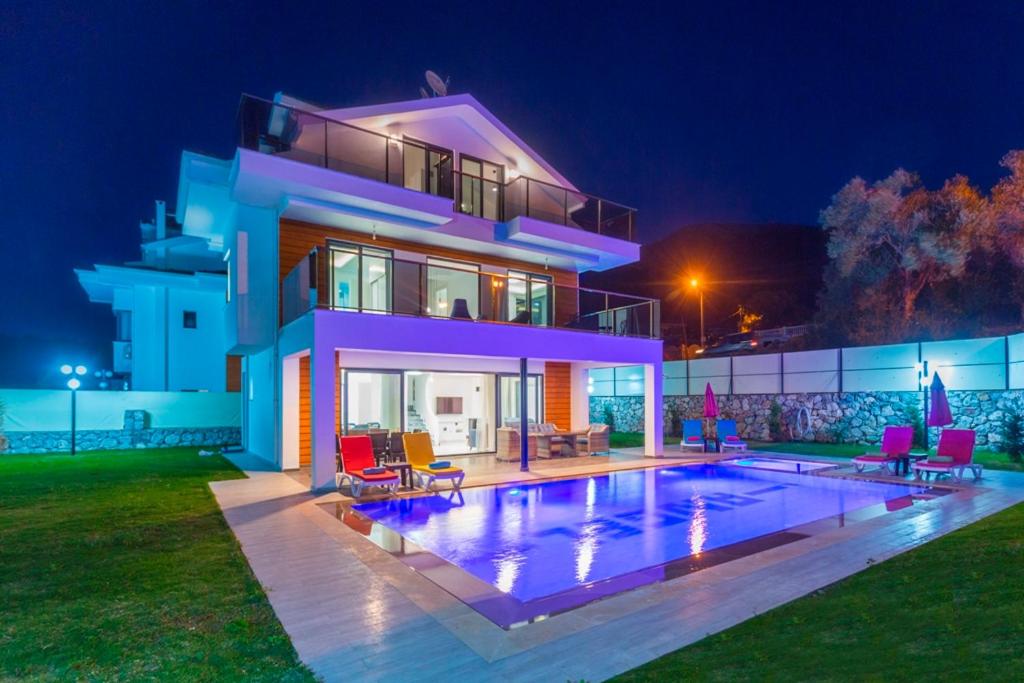 a house with a swimming pool at night at Villa Sherbella in Fethiye