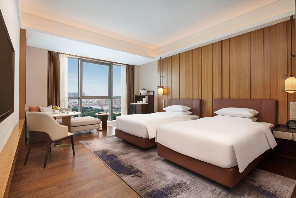 廣州的住宿－广州增城凯悦酒店，酒店客房配有两张床和一张书桌