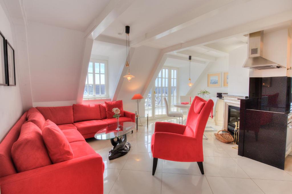 a living room with red furniture and a fireplace at Abaluga 4A in Wenningstedt