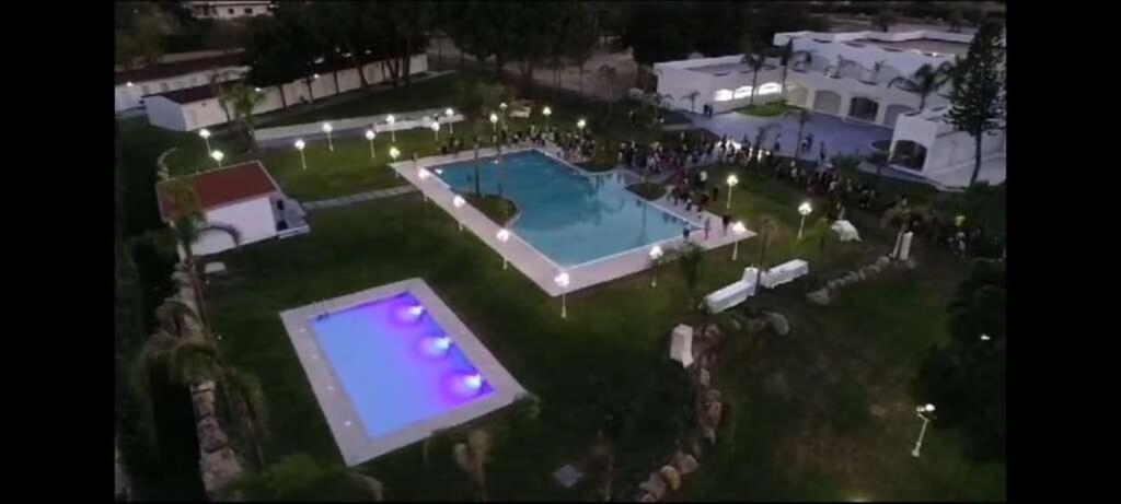 a group of people standing around a swimming pool at Villaggio Jonio Blu in Bianco