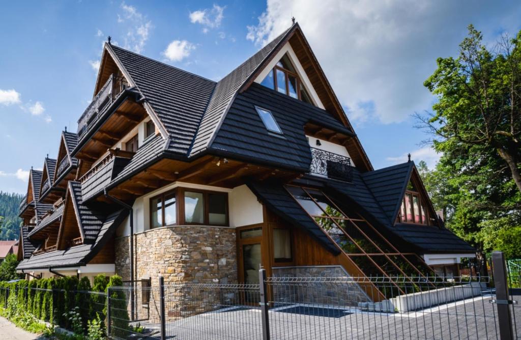 a house with a gambrel roof at TATRA Apartments Zakopane in Zakopane
