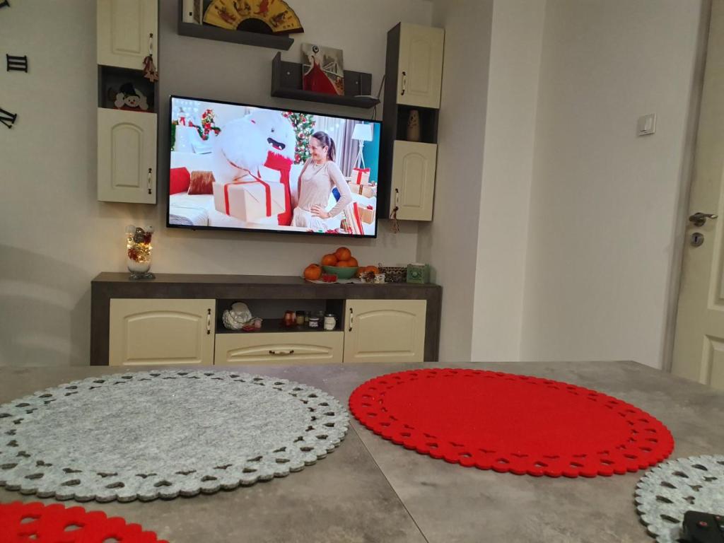 sala de estar con TV y alfombra roja en Къща в центъра, en Dobrich