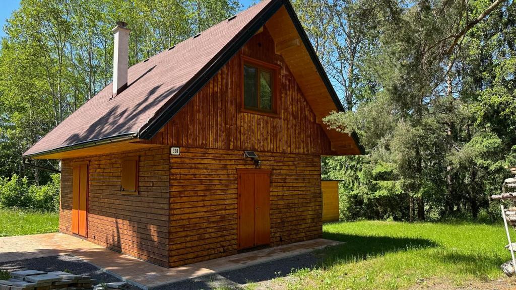 mały drewniany budynek z czerwonym dachem w obiekcie Chata na samote - Kráľova Lehota w mieście Kráľová Lehota
