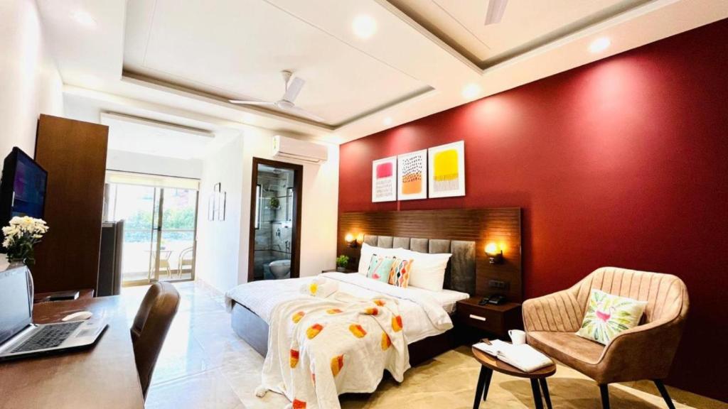 um quarto com uma parede vermelha, uma cama e uma secretária. em BluO Studio4 DLF Cybercity - Balcony, Gym TT, Lift em Gurgaon