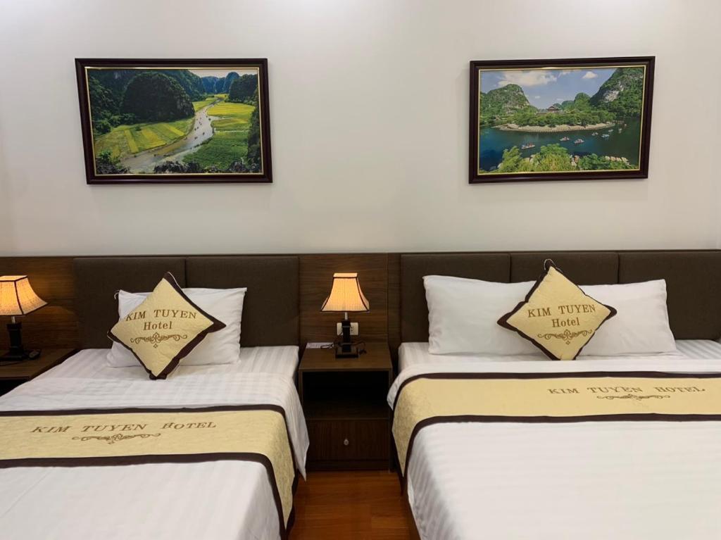 two beds in a room with two pictures on the wall at Kim Tuyen Hotel in Ninh Binh